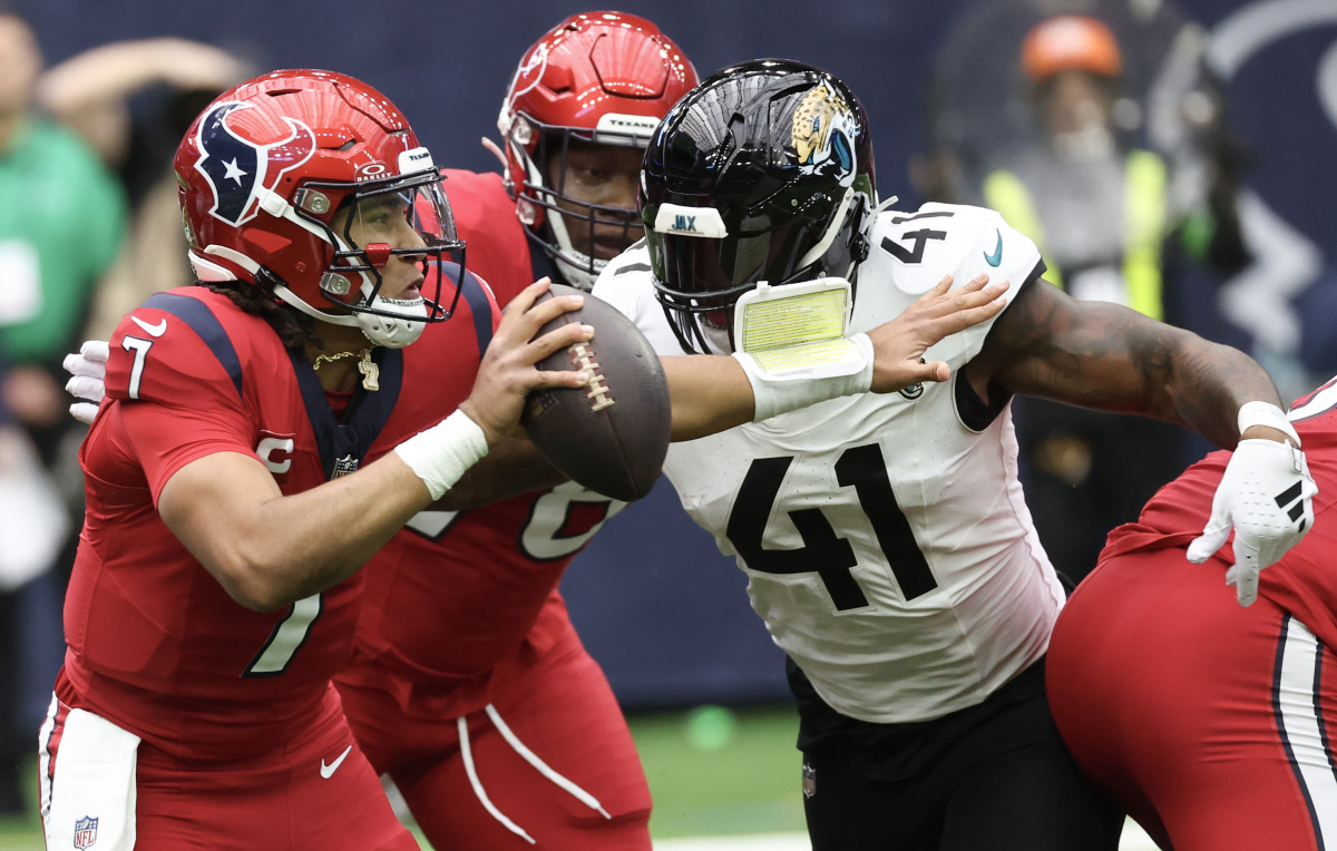 Nov 26, 2023; Houston, Texas, USA; Houston Texans quarterback C.J. Stroud (7) scrambles from Jacksonville Jaguars linebacker Josh Allen (41) in the first quarter at NRG Stadium. Mandatory Credit: Thomas Shea-USA TODAY Sports